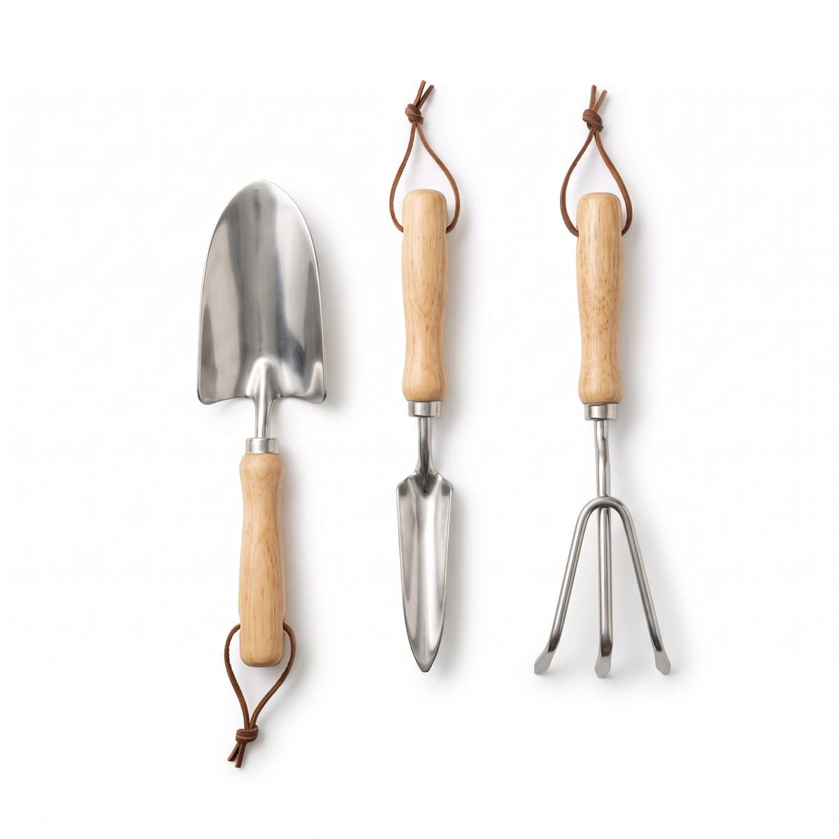 A trowel, a transplanter and a three-prong cultivator with stainless heads and wooden handles, side by side