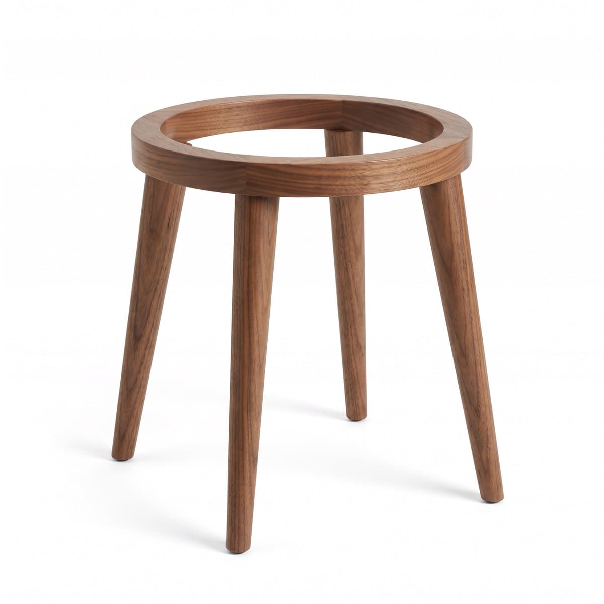 A single wooden plant stand with four splayed legs and a round top ring, standing empty